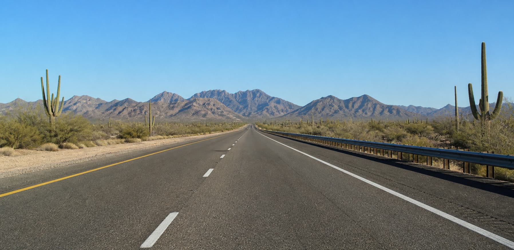 Open I-10 highway crossing the Arizona desert below rugged mountains